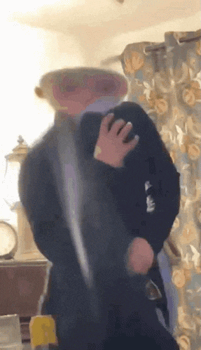a blurry picture of a person standing in a room with a clock in the background