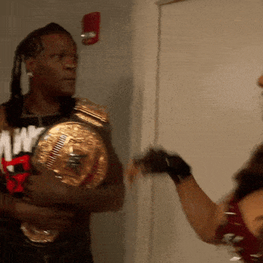 a man holding a wrestling belt that says ' my ' on it