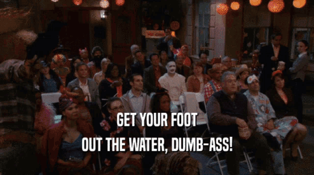 a group of people sitting in front of a screen that says " get your foot out the water dumb-ass "