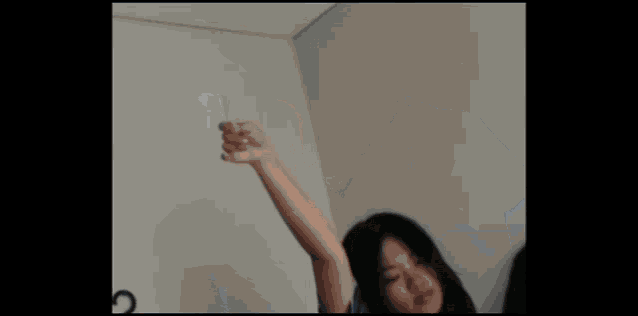 a woman is standing in front of a hanger with a black shirt hanging on it .