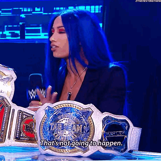 a woman with blue hair is holding a tag team championship belt and says that 's not going to happen .