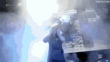 a man is standing in a dark room with a glowing light coming from the ceiling .