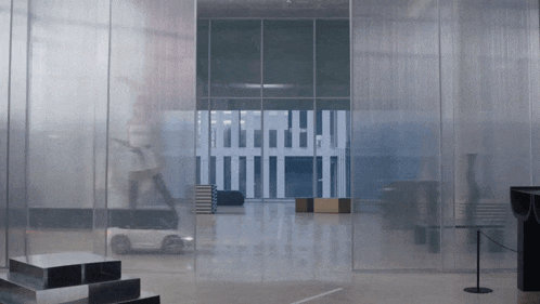 a blurred image of a car driving through a glass doorway