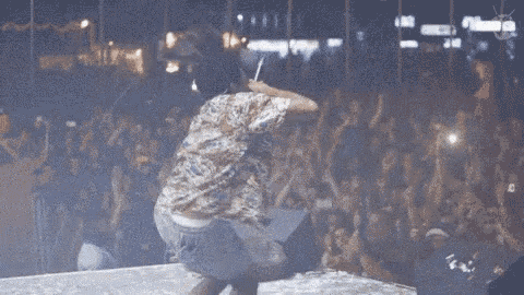 a man is dancing on stage in front of a crowd
