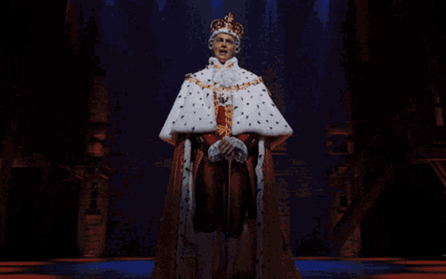 a man dressed as a king with a crown on his head stands on a stage