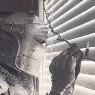 a person in a knight 's helmet is holding a string of christmas lights in front of a window