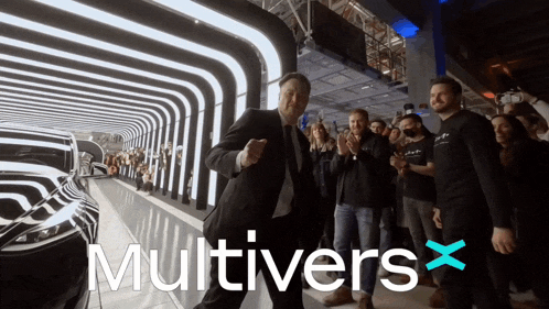 a man in a suit and tie is dancing in front of a crowd with the words multivers x behind him