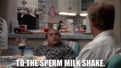 two men are sitting at a table talking to each other and one of them is saying `` to the sperm milk shake ''