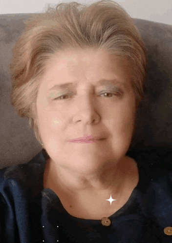 a close up of a woman 's face with her eyes closed and a star on her neck