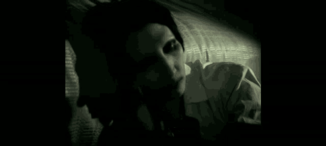a close up of a person 's face in a dark room .