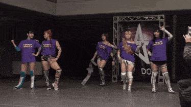 a group of women standing in front of a sign that says do on it