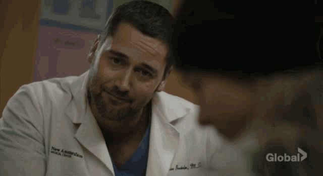 a man in a white lab coat with the name new amsterdam on the front