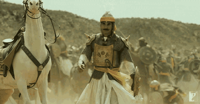 a man in armor stands next to a horse with the letter p on it