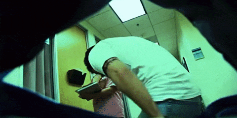 a man in a white shirt stands in a hallway