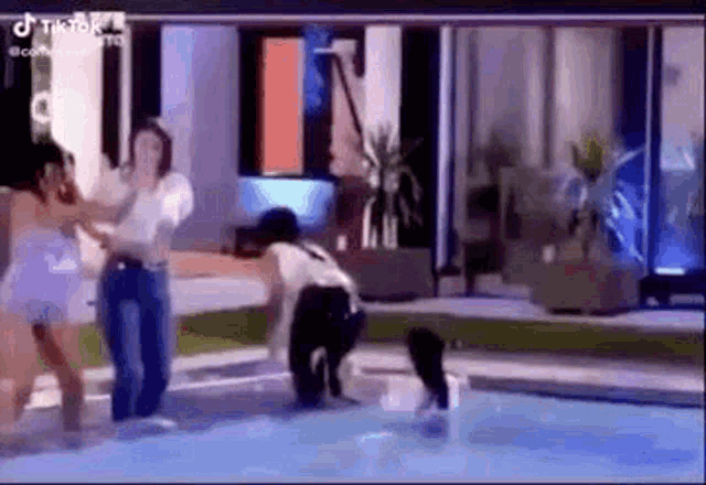 a man and a woman are standing in a pool .
