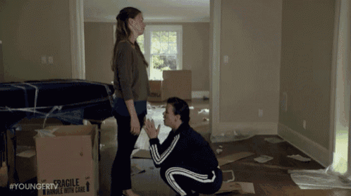two women standing next to each other in a room with fragile boxes