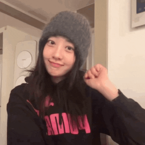 a woman wearing a gray hat and a black hoodie that says adily on it