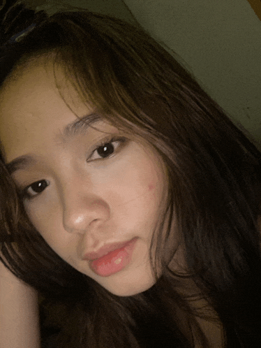 a close up of a girl 's face with a red spot on her face