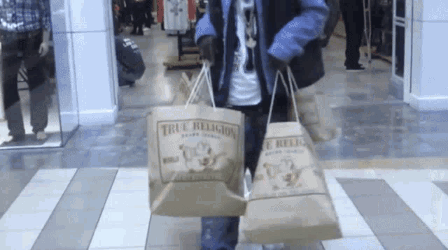 a person carrying a bag that says true religion on it