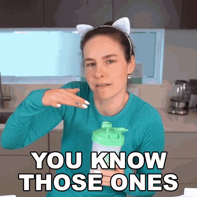 a woman wearing a cat ear headband holds a green bottle and says " you know those ones "