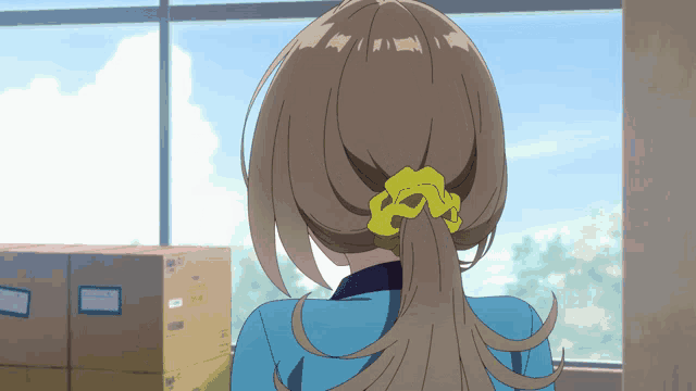 a woman with a yellow scrunchie in her hair stands in front of a window