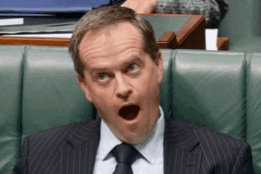 a man in a suit and tie is making a funny face
