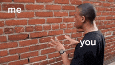 a man is standing in front of a brick wall with the words me and you written on it