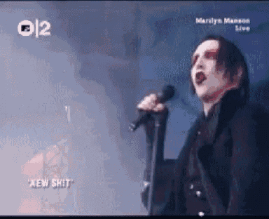 marilyn manson is singing into a microphone in a video