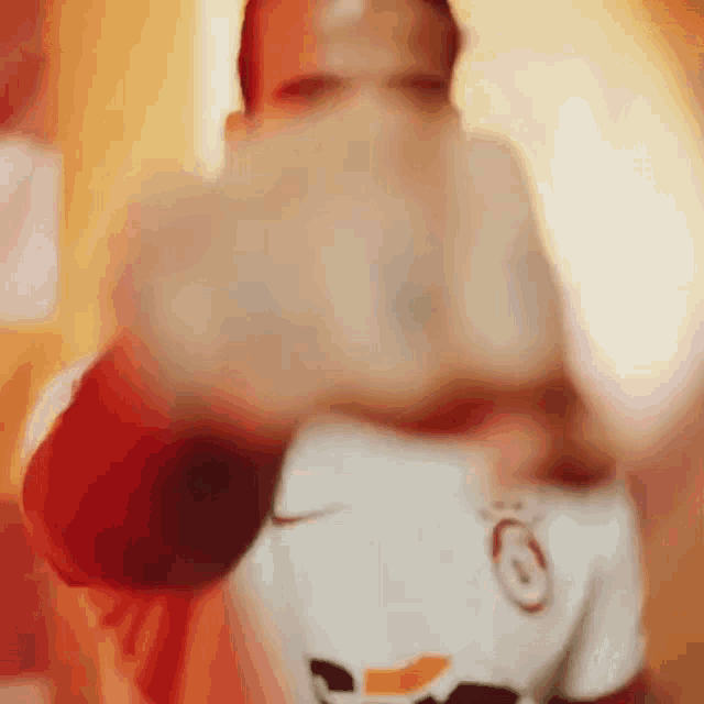a blurry picture of a man wearing a white shirt with the letter g on it .