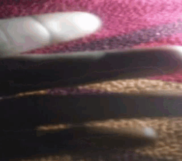 a close up of a person 's hand holding a knife on a pink rug .