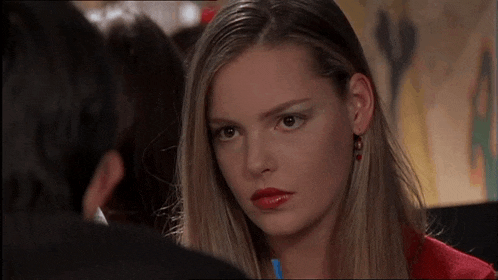 a woman in a red coat is looking at a man in a black jacket .