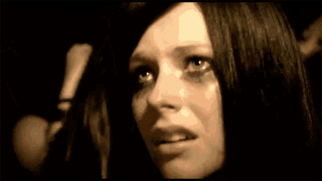 a close up of a woman 's face with tears running down her eyes