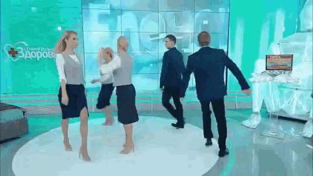 a group of people are dancing on a stage in front of a sign that says ' здоров ' on it