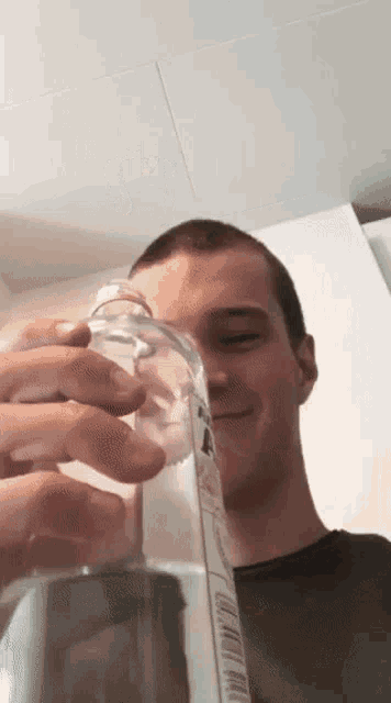 a young man is holding a bottle with a label that says ' a ' on it