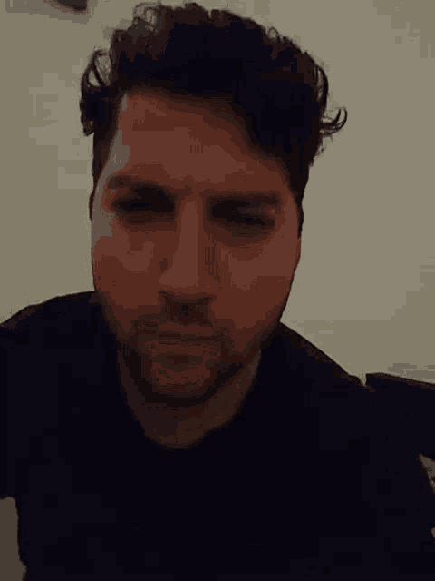 a close up of a man 's face with a black shirt on