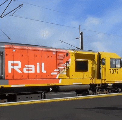 a yellow train with the number 0777 on the side of it