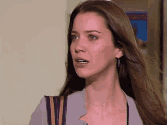 a close up of a woman 's face with long brown hair