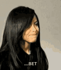 a woman with long black hair is making a funny face and says `` bet '' .