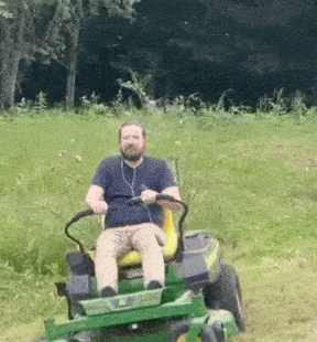 a man is riding a john deere lawn mower in a grassy field