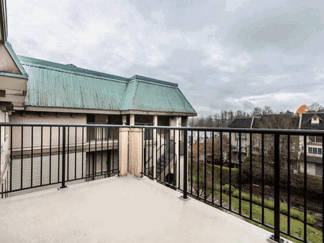 a balcony with a view of a building and a green roof