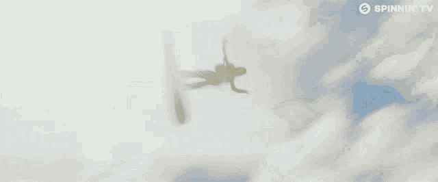 a plane is flying through a cloudy sky with the words spinnin ' tv on the bottom