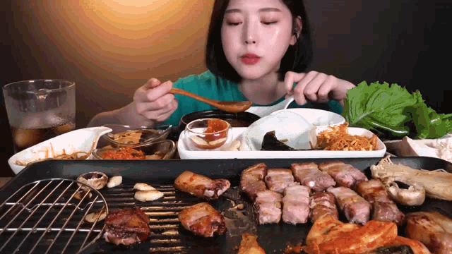 a woman is sitting at a table eating a variety of foods