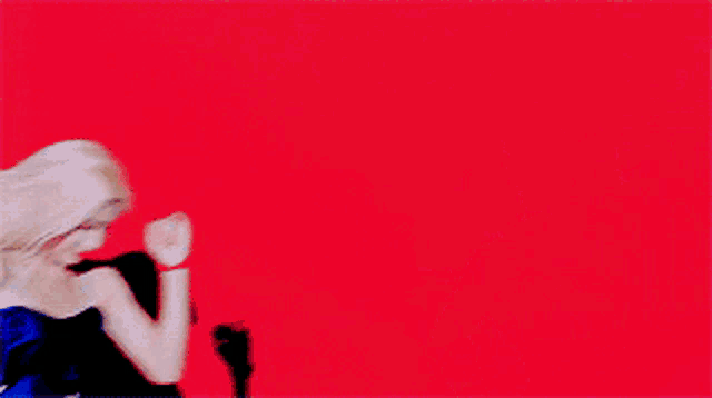 two women are dancing on a red background