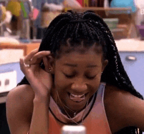 a woman with braids is smiling while sitting at a table .