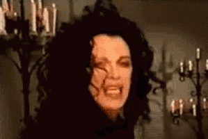 a woman with black hair is making a funny face in front of candles .