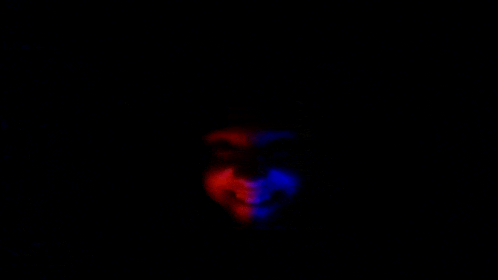 a red and blue light is shining on a dark background .