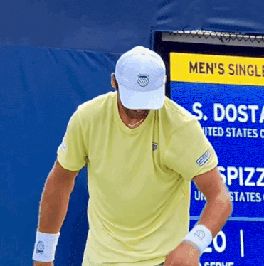 a man standing in front of a sign that says men 's single s. dosta