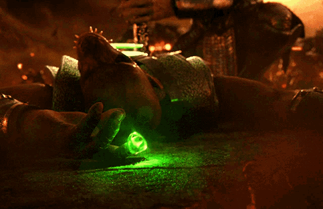 a person laying on the ground with a green light coming out of their hand