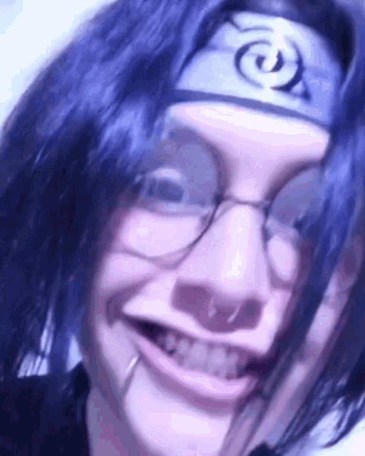a close up of a person wearing glasses and a headband with a symbol on it .
