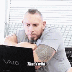 a man is sitting in front of a vaio laptop and saying that 's wild .